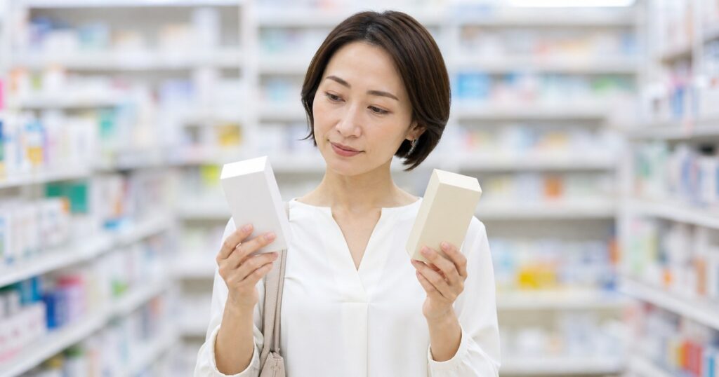 ドラッグストアの漢方薬コーナーで商品を見比べる日本人女性
