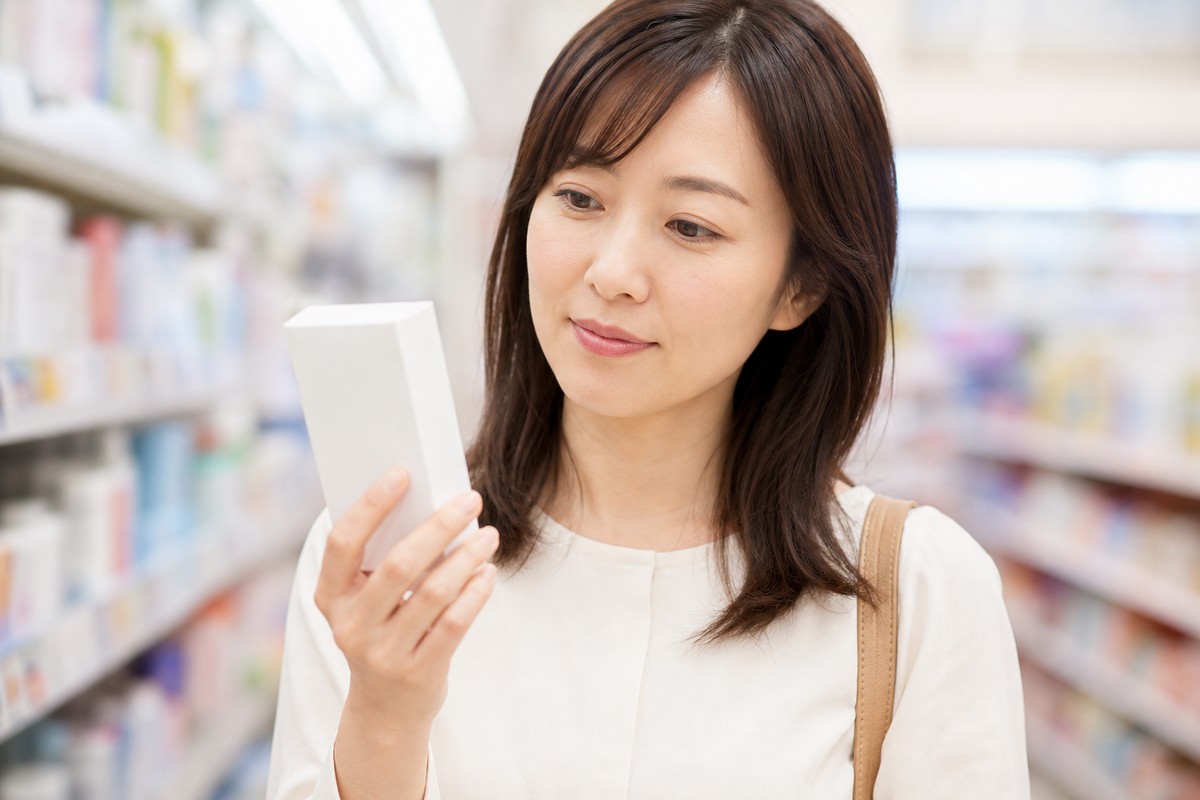 薬局で納得した表情で商品を手に取る日本人女性